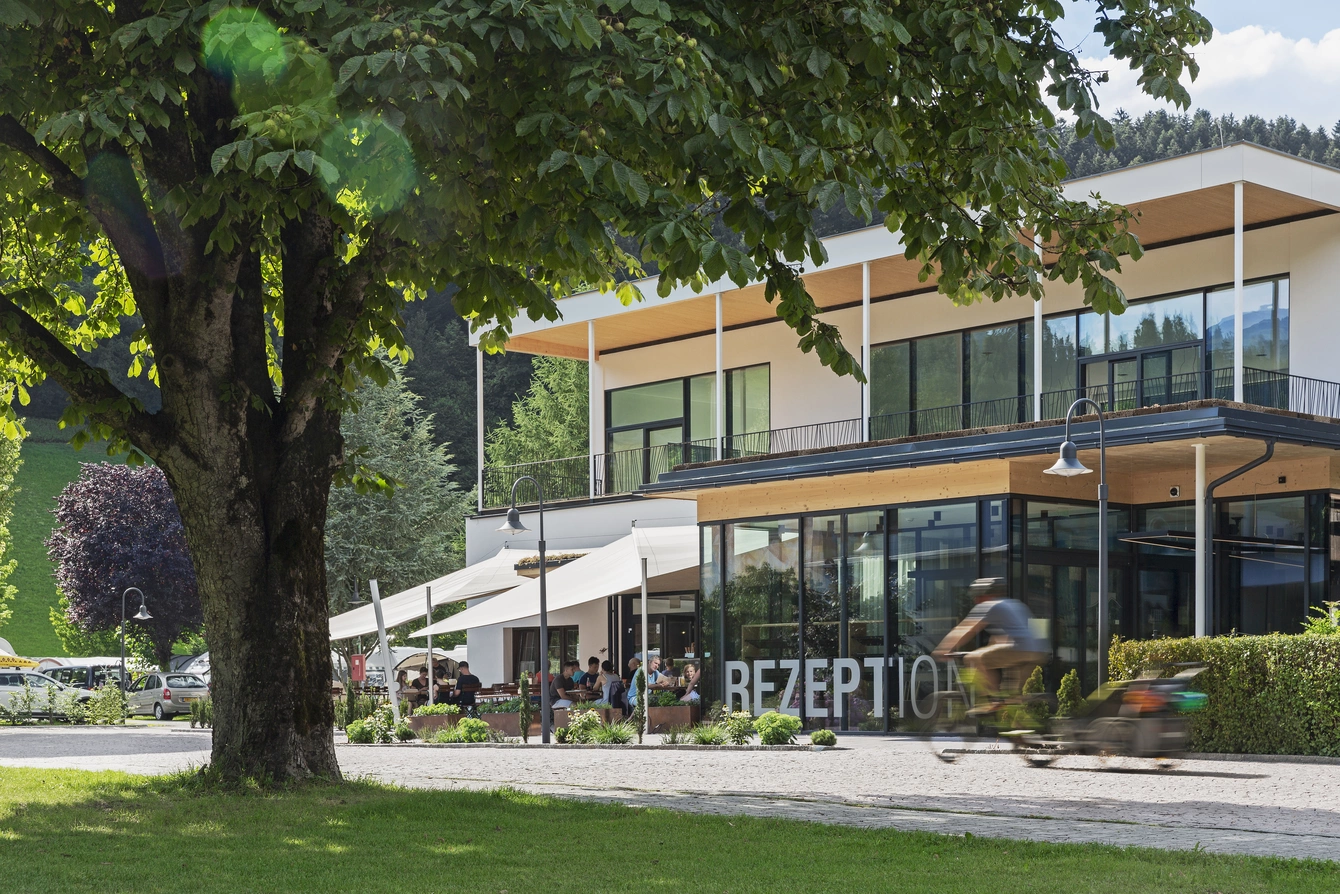 Rezeption & Shop ©Natürlich HELL Camping & Aparthotel Die Rezeption des Natürlich Hell von außen betrachtet mit einem großen Baum im Vordergrund.