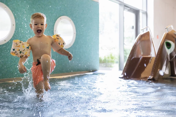 Badespaß für Kinder Ein Kind läuft lachend durch das Kinderbecken