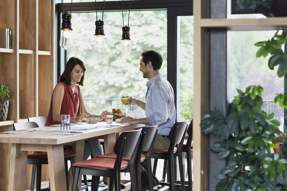 Regionales Frühstück im Natürlich Hell Ein Paar das im Frühstücksraum sitzt und dort Kaffee trinkt.